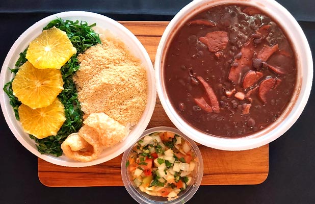 Feijoada Vegana servida com couve, farofa e laranja